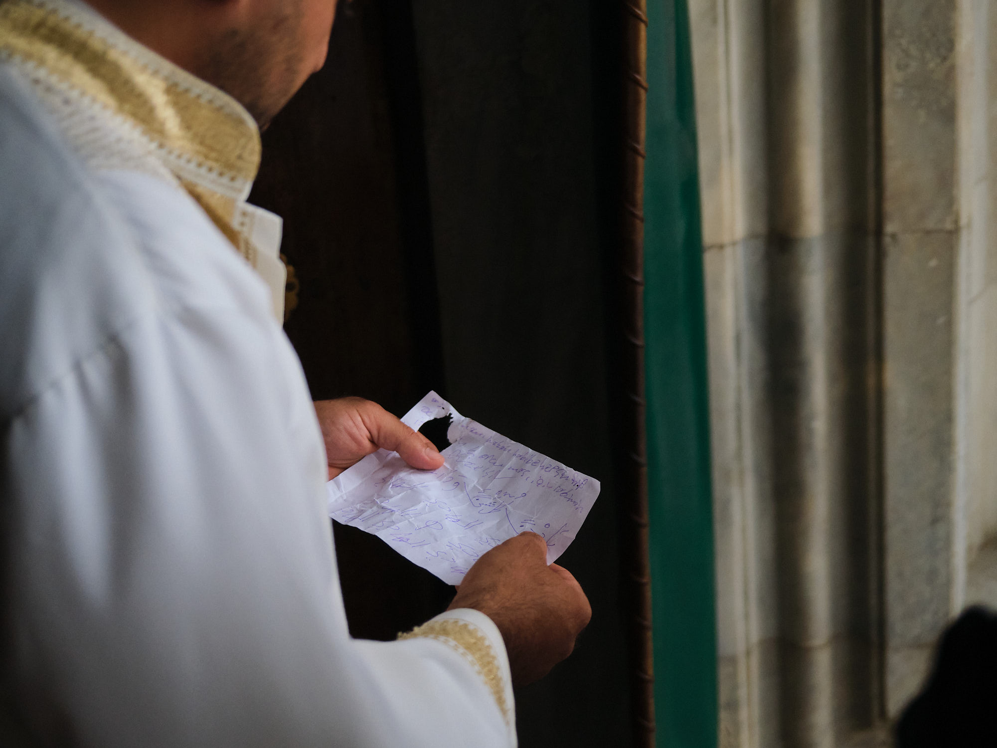 imam handing woman a note of prayers.