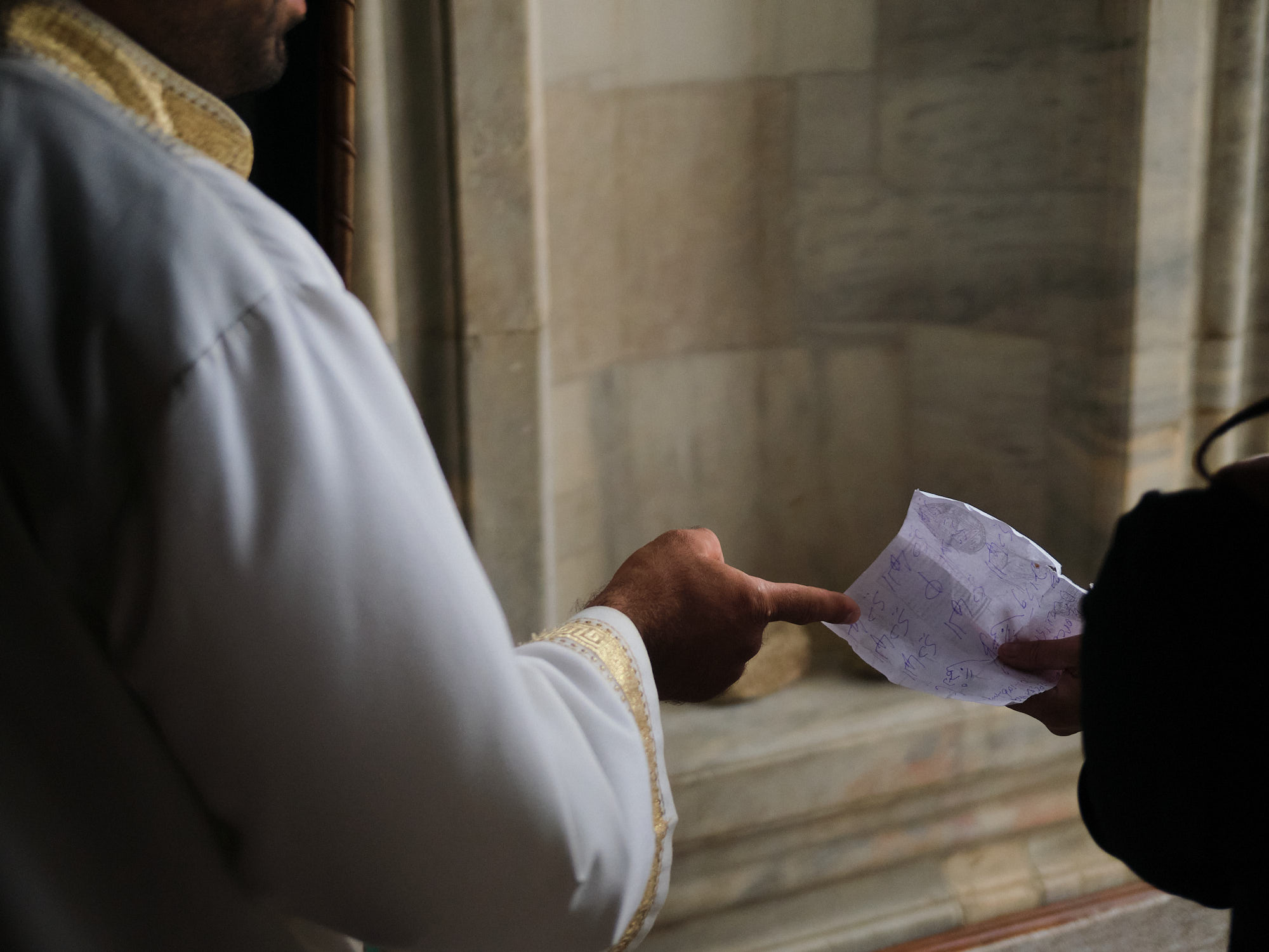 imam handing woman a note of prayers.